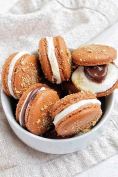 a white bowl filled with cookies covered in chocolate and marshmallows on top of a table