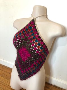 a white mannequin wearing a multicolored crochet knitted top