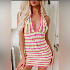 a woman in a pink and green crochet swimsuit posing for the camera