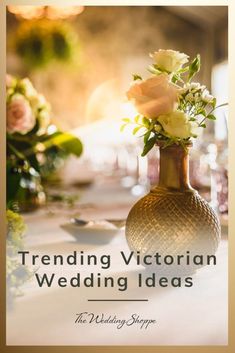 a vase filled with flowers sitting on top of a table next to candles and wine glasses