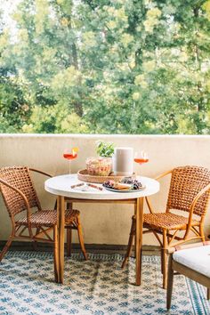 two chairs and a table on a balcony