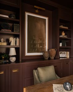 a room with some bookshelves and a painting hanging on the wall above it