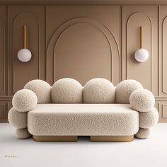 a white couch sitting on top of a floor next to a wall mounted light fixture