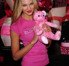 a woman holding a pink teddy bear in her hands