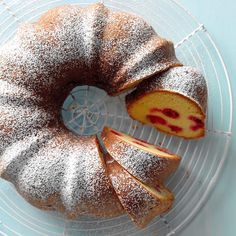 a bundt cake on a wire rack with powdered sugar and slices cut out