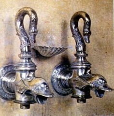 two antique style faucets are attached to the wall with metal fittings on them