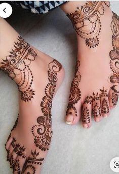 two feet with henna tattoos on them