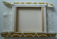 a white and yellow photo frame sitting on top of a wall