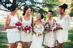 a group of women standing next to each other holding bouquets in their hands and laughing