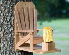 a wooden chair sitting on top of a tree next to a corn cob