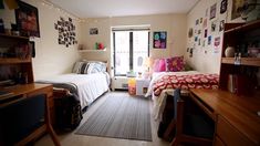 a bedroom with two beds, desks and pictures on the wall above them in front of a window