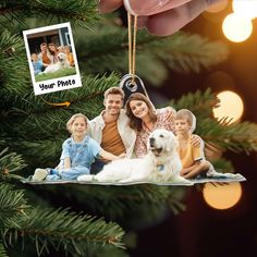 a family ornament hanging on a christmas tree with their dog and two children