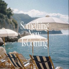 some chairs and umbrellas on the beach by the water with words that say something new is coming