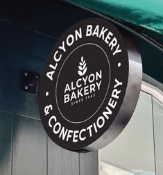 the sign for alcyon bakery and confectionery hangs from the side of the building