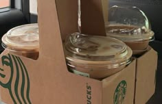 two starbucks coffee cups in a cardboard box