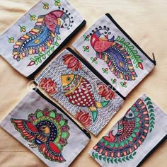 four embroidered pouchs with colorful designs on them