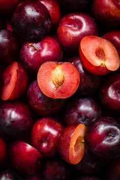 a pile of plums with one cut in half