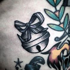 a close up of a tattoo on the back of a person's stomach with an apple and bell