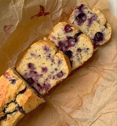 three slices of blueberry bread sitting on top of brown paper