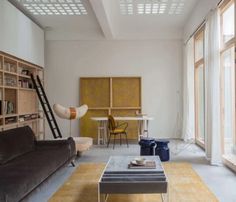 a living room filled with furniture and lots of windows