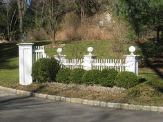 a white picket fence in the middle of a park