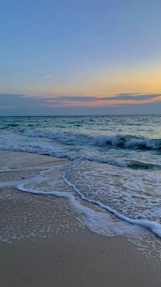 the sun is setting over the ocean waves