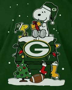 a green bay packers shirt with a snoopy christmas tree and football on the front