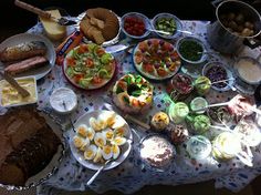 a table filled with lots of food on top of a blue and white cloth covered table