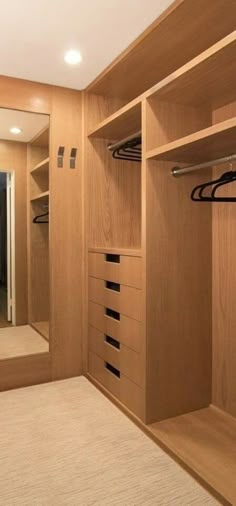 an empty walk - in closet with wooden shelves and drawers