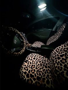 the interior of a car with leopard print cloths and black leather steering wheel covers