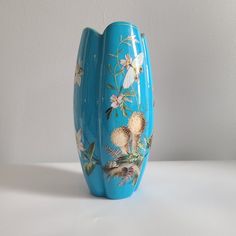 a blue vase with flowers painted on it