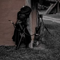 a woman dressed as a witch leaning against a building