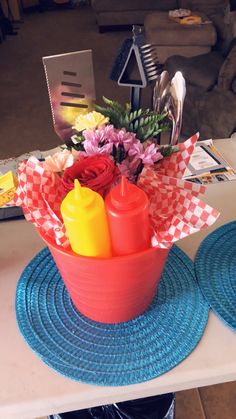 there is a red bowl with flowers in it on the table