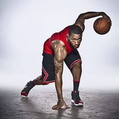 a man in red shirt and black shorts holding a basketball