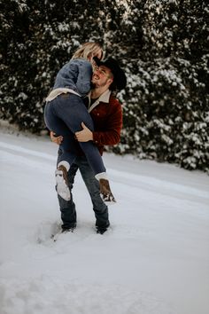 a man holding a woman in the snow