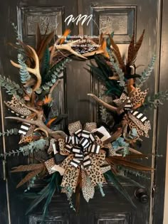 a wreath made out of antlers, feathers and other things on the front door