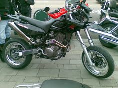 a motorcycle parked next to other motorcycles on a sidewalk