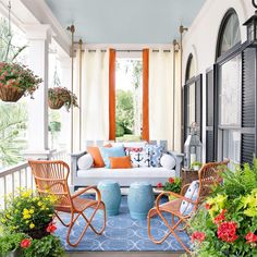 an image of a porch with chairs and flowers on the front porch, including potted plants