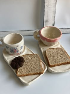 two pieces of bread with chocolate cookies on them next to a cup and saucer