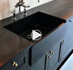 a black kitchen sink sitting under a faucet