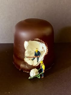 there is a small figurine next to a chocolate cake