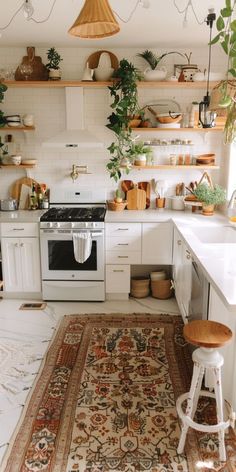 a kitchen filled with lots of white furniture and decor