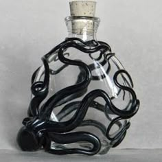 a black and white glass bottle with an octopus inside