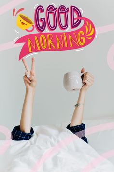 a woman laying in bed with her hands up and holding a cup that says good morning