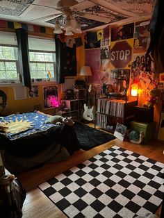 a bedroom with a checkered rug and lots of posters on the wall above it