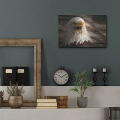 an eagle painting on the wall above a mantle with books, plants and other items