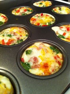 a muffin tin filled with mini pizzas on top of a stove