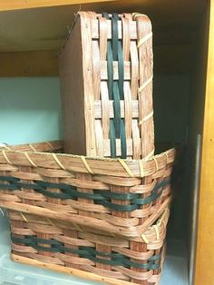 two wicker baskets sitting on top of a wooden shelf