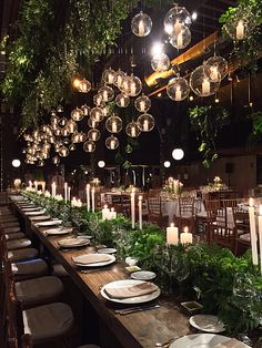 a long table is set with plates and candles