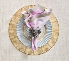 a plate with a napkin on top of it and a purple flower in the center